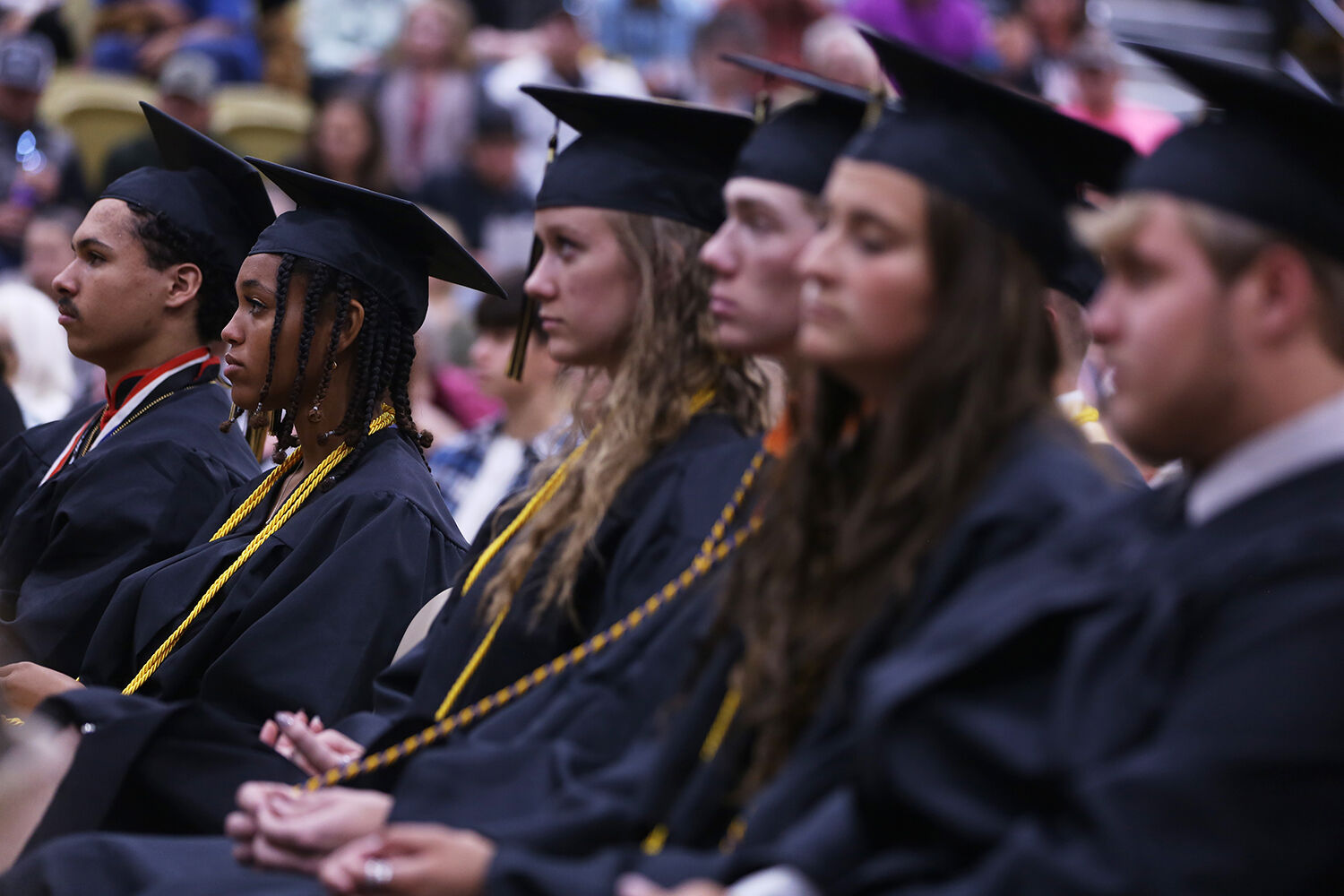 Jordan Hunt, left, sits in line with her peers as they listen to the valedictorian address